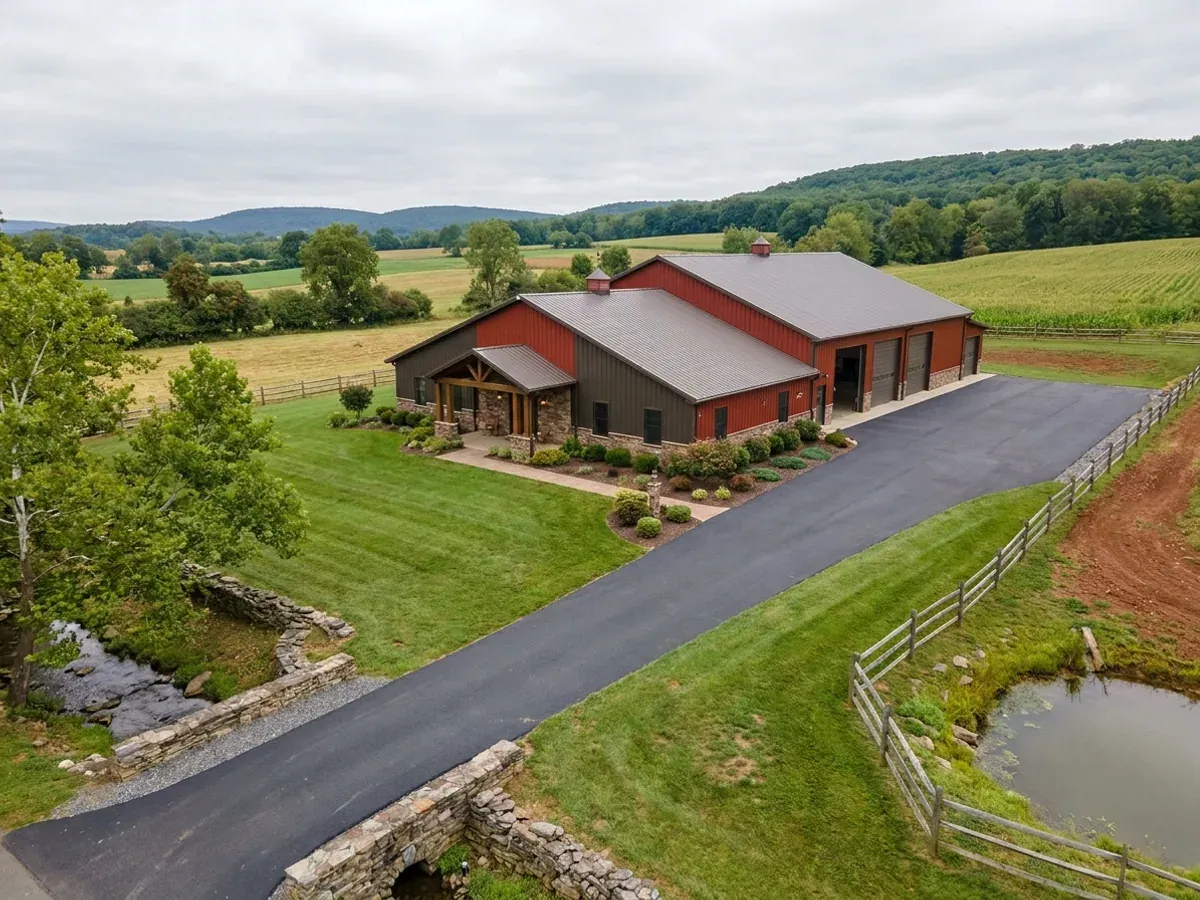 A completed barndominium home viewed from the front corner, with finished landscaping, a covered entry porch and an attached shop bay.